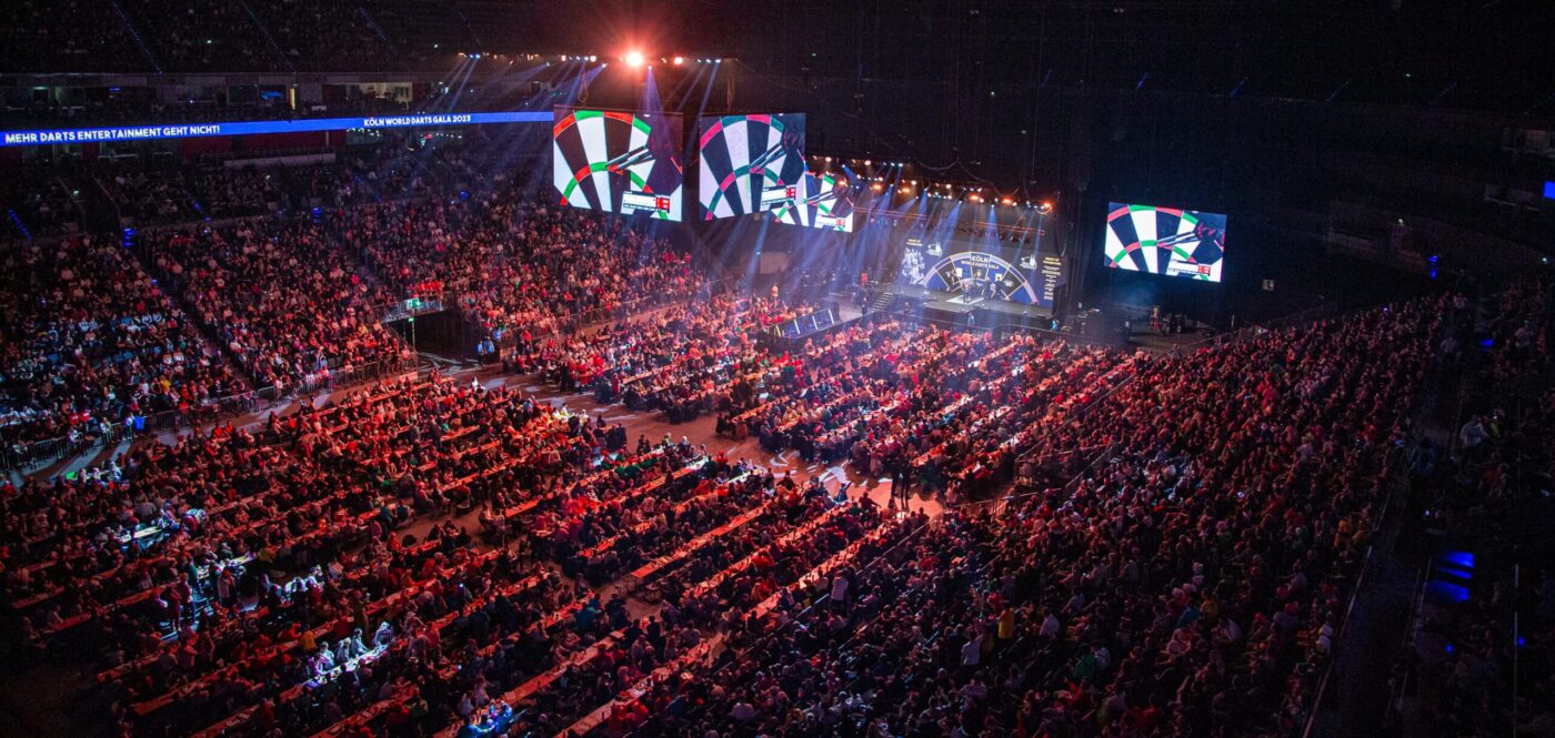 Ausverkaufte Halle in der Totale mit Blick auf die Bühne der Köln World Darts Gala Ausverkaufte Halle in der Totale mit Blick auf die Bühne der Köln World Darts Gala