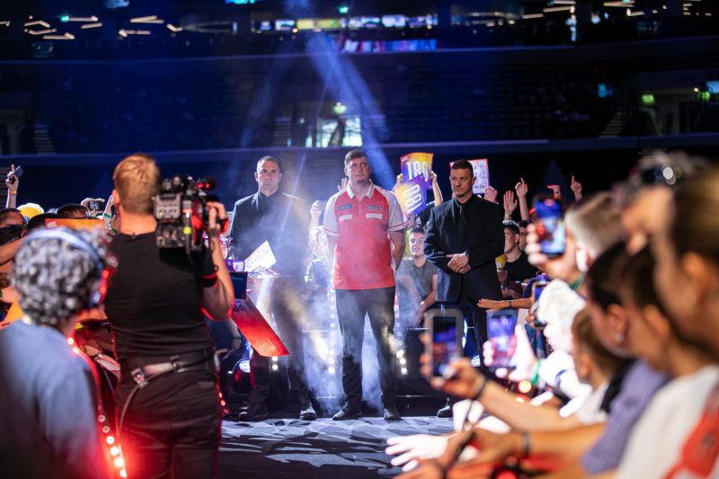 Niko Springer vor seinem Walk-on, neben ihm Sicherheitsleute und hinter ihm jubelndes Publikum.