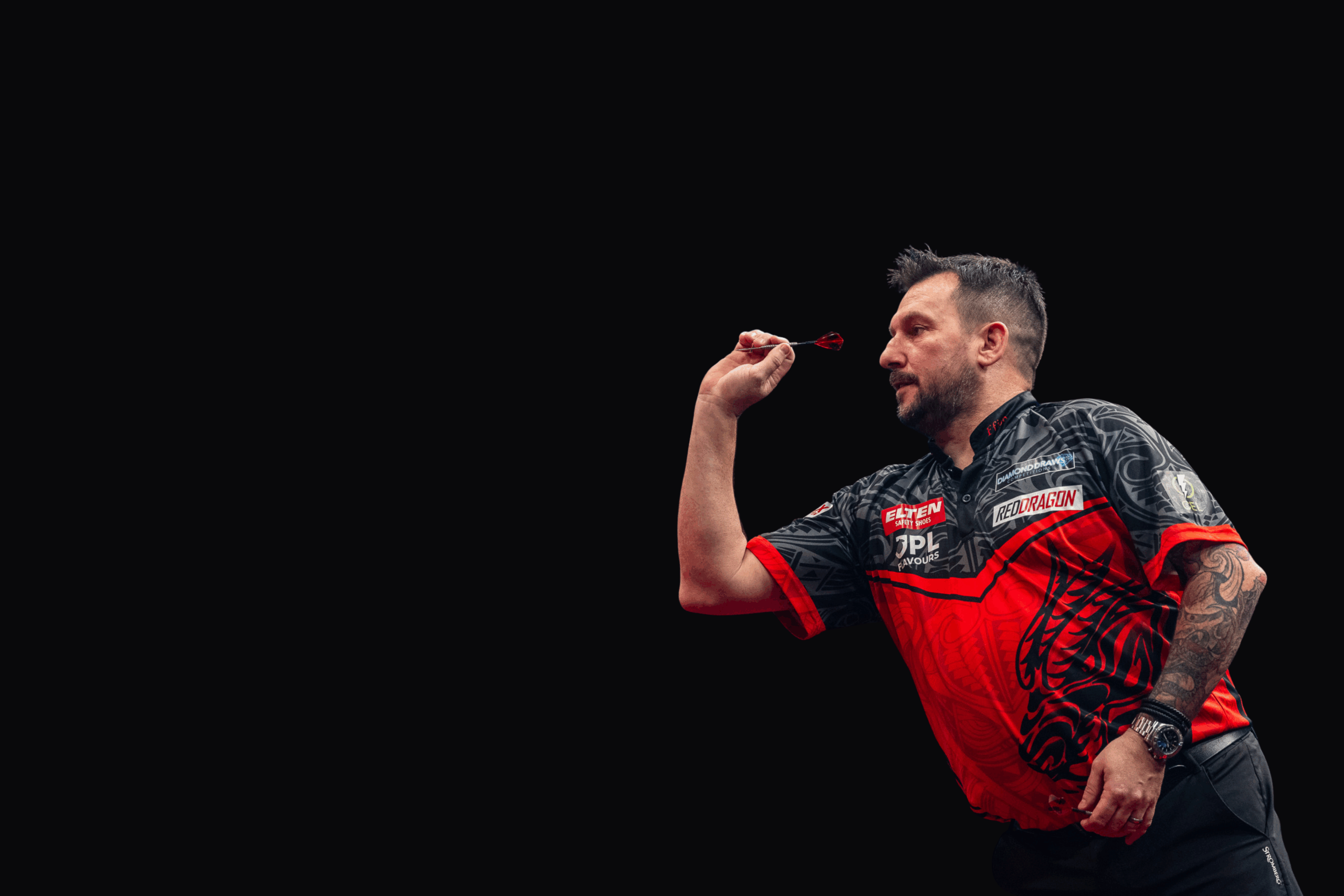 Nahaufnahme von Jonny Clayton während einer Aufnahme mit Dartpfeil in der rechten Hand und konzentriertem Blick nach vorne
