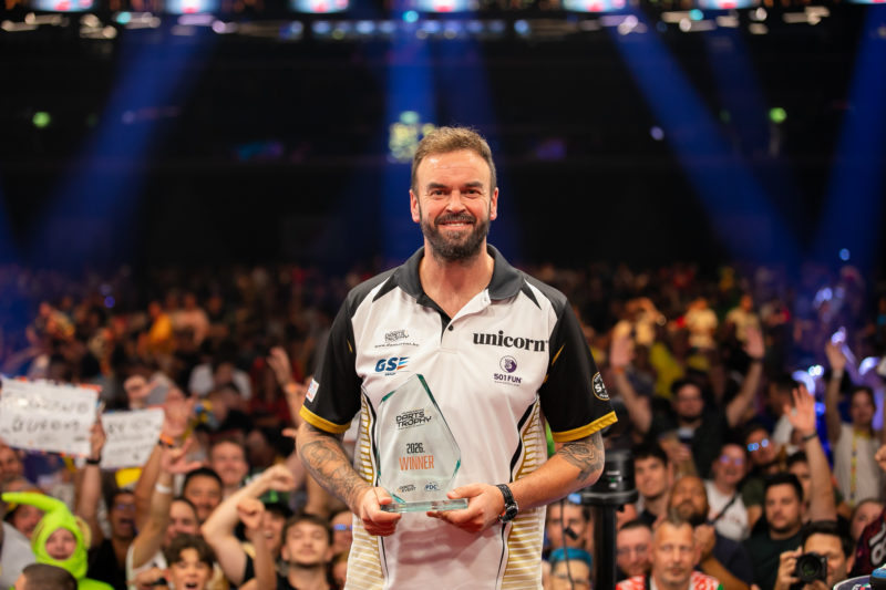 Ross Smith posiert als Gewinner der Hungarian Darts Trophy 2026 mit Trophäe vor jubelndem Publikum in Budapest.