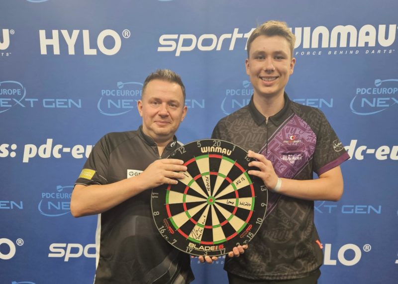 Daniel Klose und Lenny Schlüter halten glücklich eine Dartscheibe nach der PDC Europe Next Gen